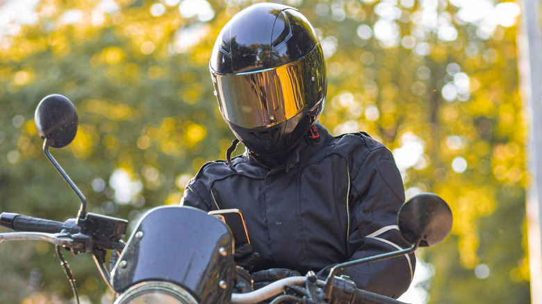 Biker on a classic street motorcycle in a motorcycle jacket and helmet