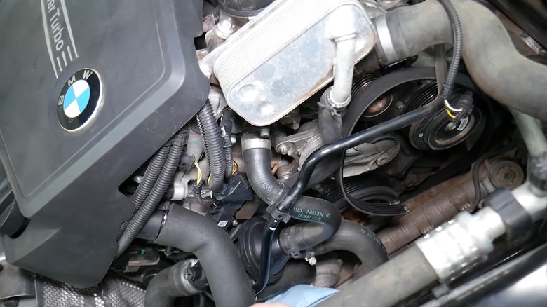 BMW engine bay showing a broken serpentine belt