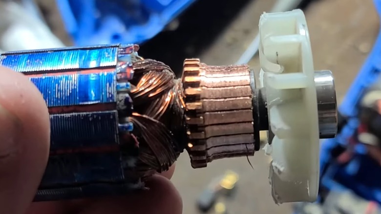 A person holding a brushed tool motor.