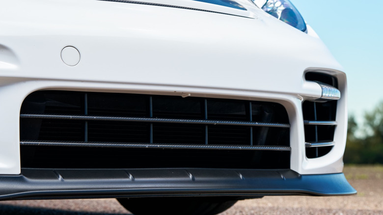 Close-up of the lower front end of a modern vehicle showing black plastic air dam