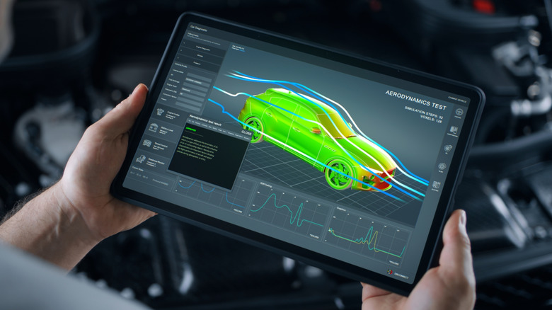 An automotive technician examines an aerodynamics test readout on a tablet display
