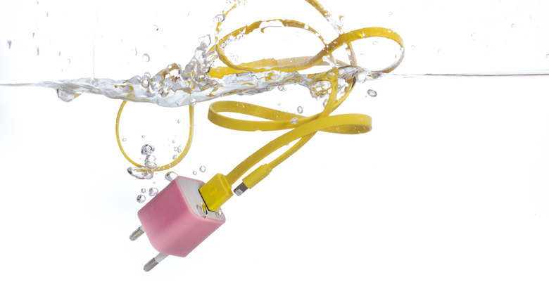pink and yellow USB charger submerged in water