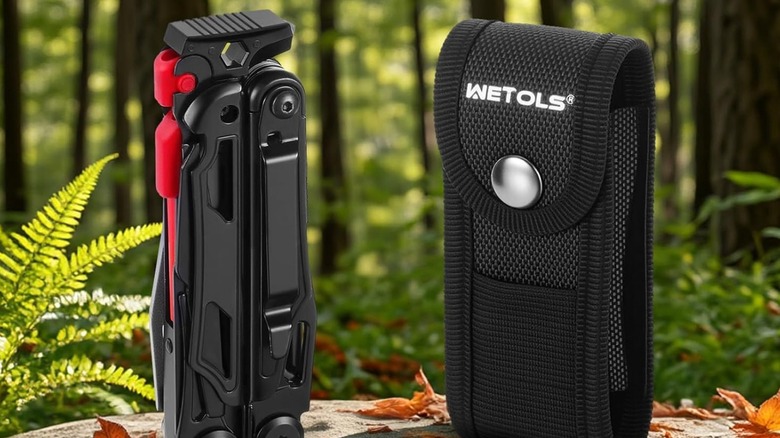 Wetols 27-in-1 multi-tool sitting on stump in woods next to nylon case