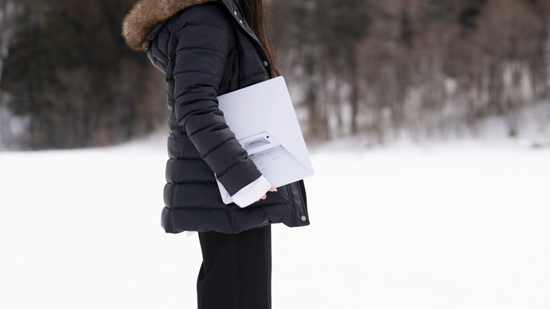 Woman holding unconnected Starlink Mini outdoors