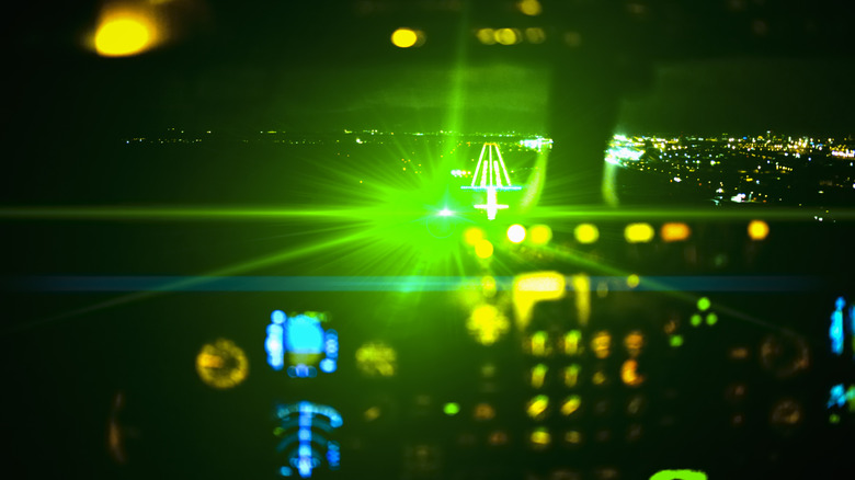 A graphic of a laser beam reflecting on the cockpit of an aircraft at night.