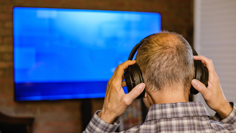 man watching TV with headphones