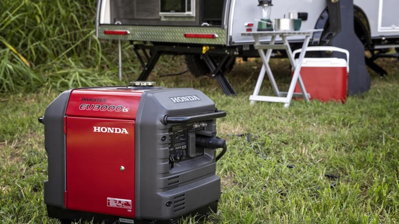 A 3,000-watt Honda generator on the grass near an RV.