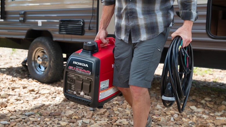 A person carrying a 2,200 watt Honda generator.