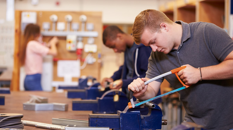 Students learning how to cut a pipe
