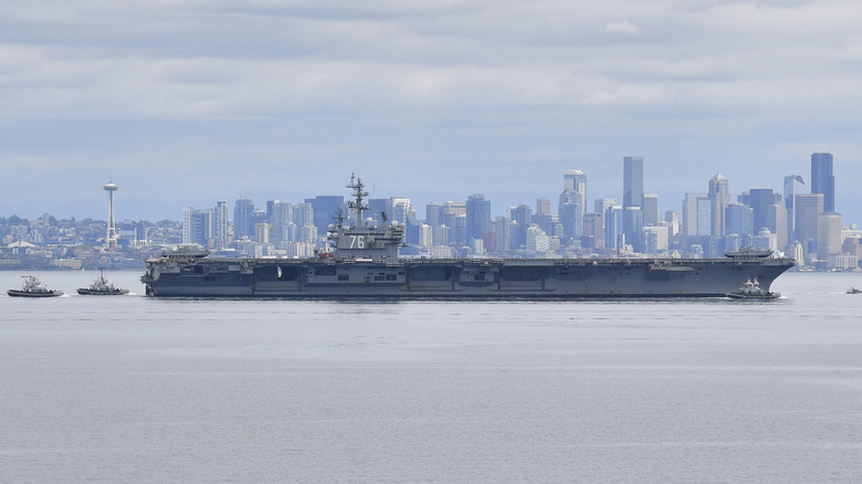 USS Ronald Reagan being escorted from port by tugs