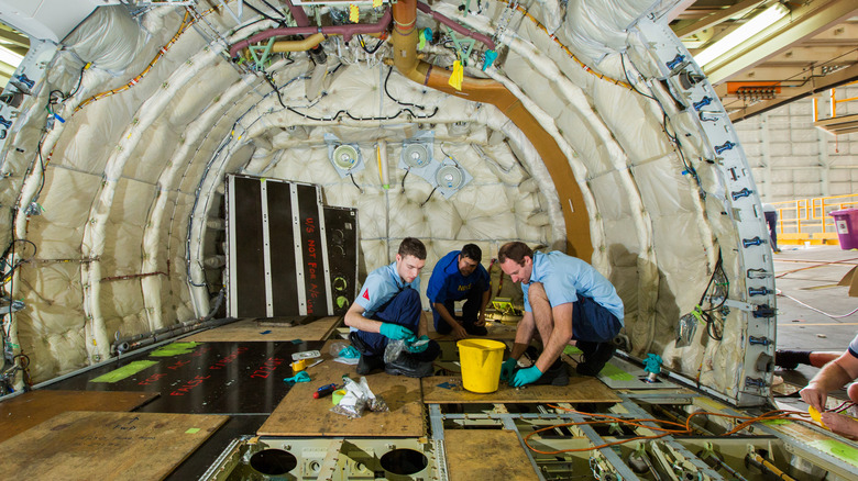 technicians aboard a disassembled qantas aircraft perform inspections