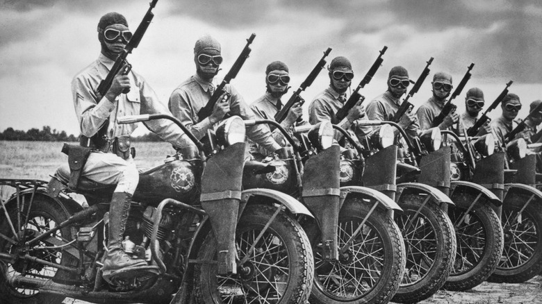 World War II soldiers on motorcycles holding rifles