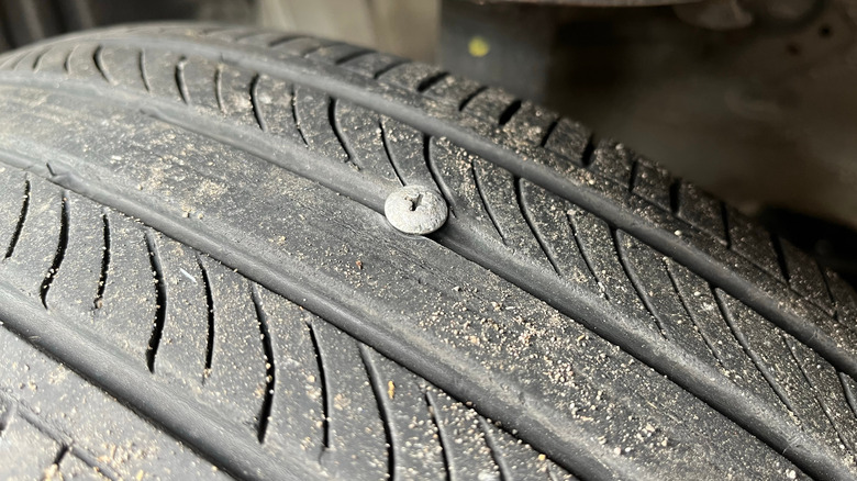 Car tire punctured by a bolt