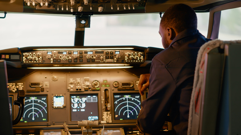Pilot looking at instruments in aircraft cockpit.