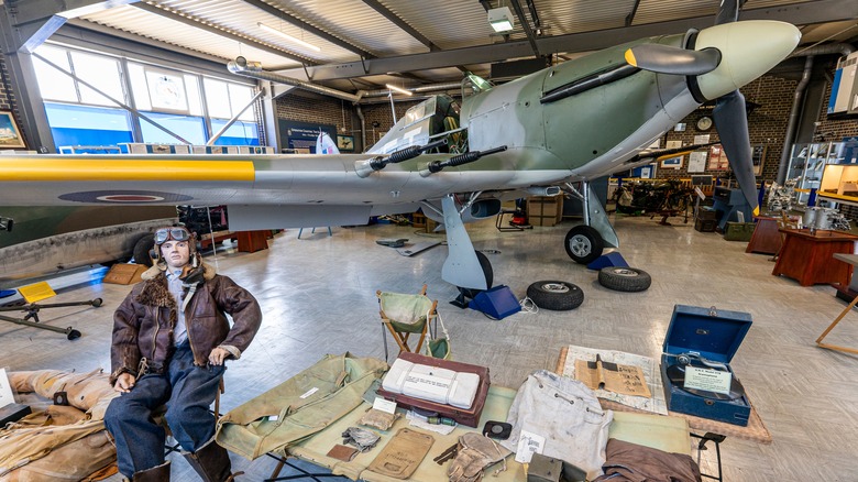 Aircraft and pilot on display in museum.