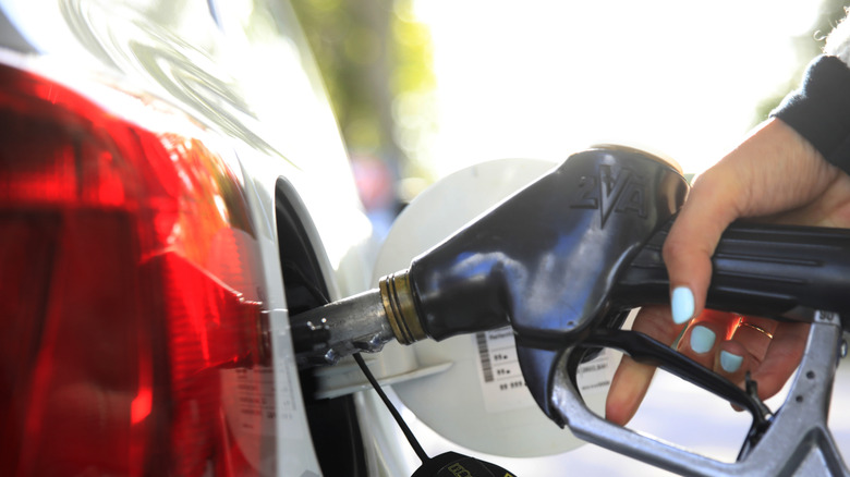A person fueling a car at a pump.