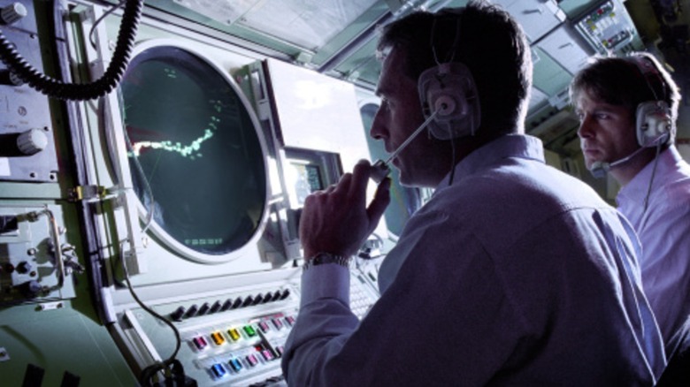 Submarine crew looking at sonar instruments