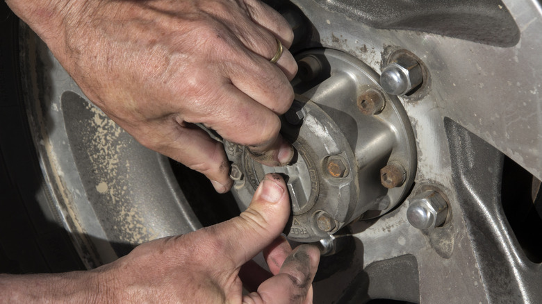 A person adjusting locking hubs on wheels