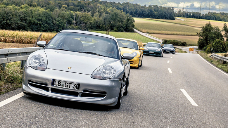 A group of Porsche 911 996 GT3s on the road