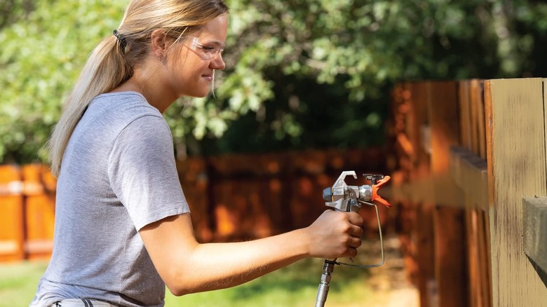 woman using Graco Magnum paint sprayer