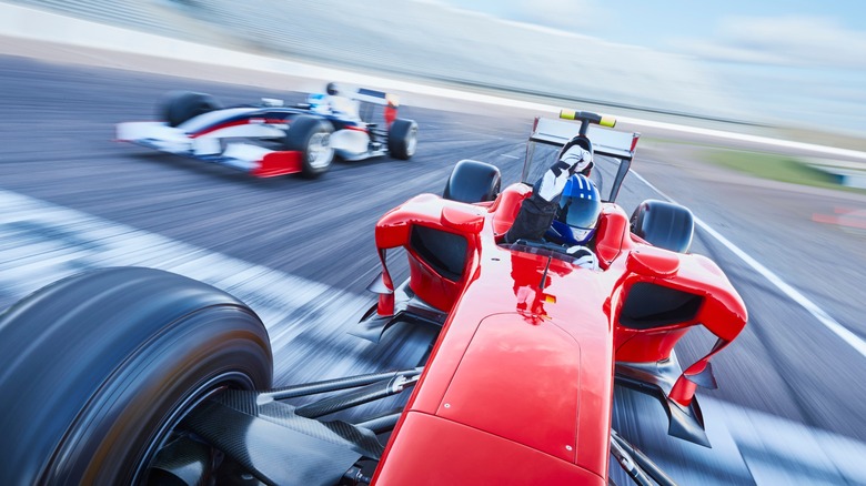 An open wheel race car driver celebrating a victory