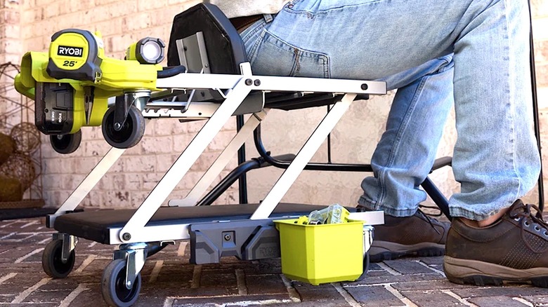 Person sitting on Ryobi 18V creeper seat