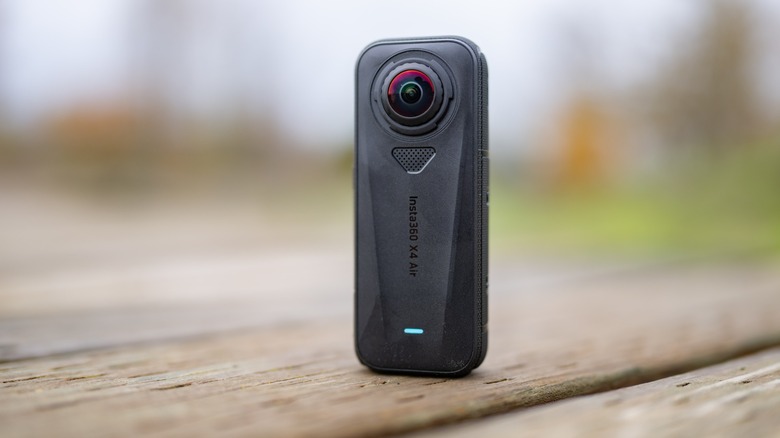 The Insta360 X4 Air on a wooden surface with an out of focus background.
