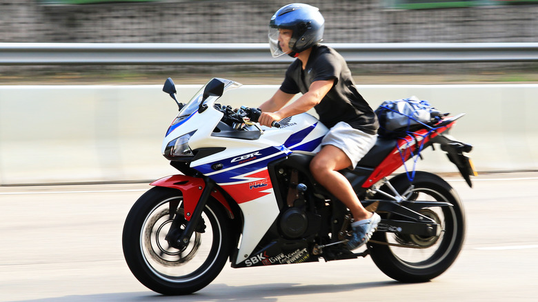 A biker riding a Honda CBR500R motorcycle on a highway