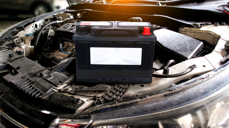 Car battery with blank white sign , battery placed on engine compartment for car electronic system