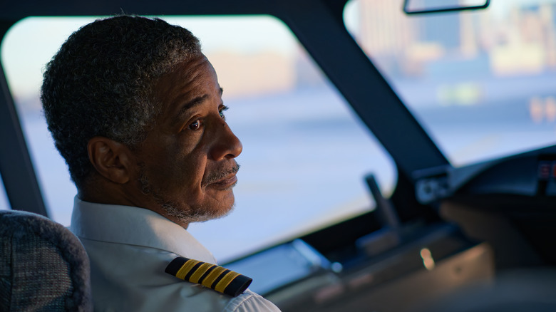 Airplane pilot in cockpit looks back over their shoulder.