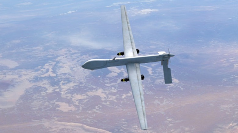 Military drone flying over desert