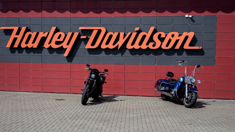 Harley Davidson dealership sign with two Harley motorcycles parked in front of it