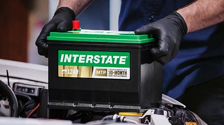 Mechanic putting Interstate battery in a car