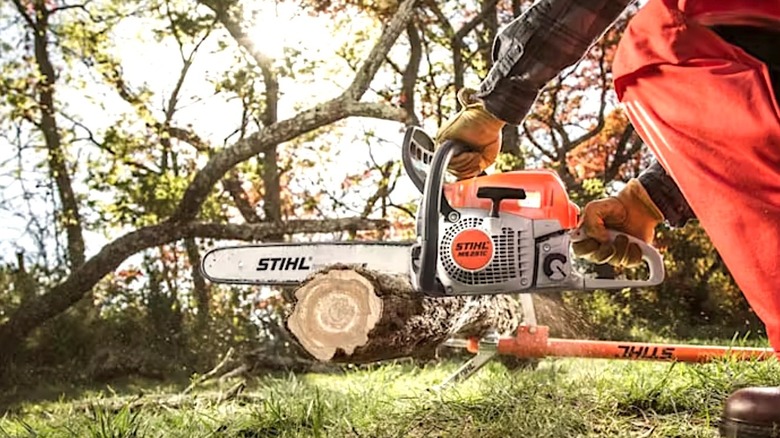 Person using Stihl chainsaw