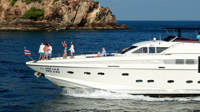 passengers enjoying themselves on the front of a yacht