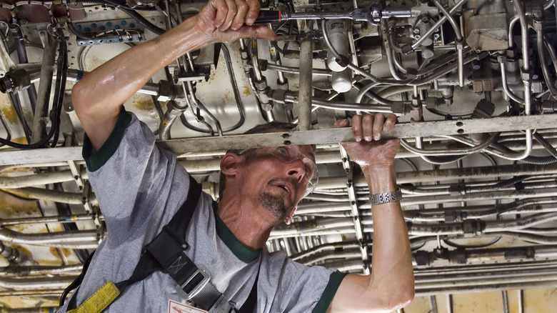 Aircraft engineer inspecting the underside of a jetliner