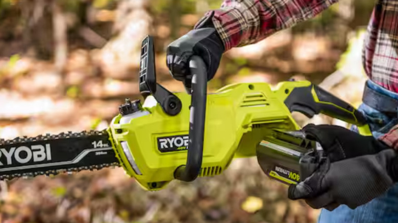 A man inserting a battery into the Ryobi 40V chainsaw