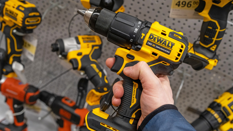 A man holding a DeWalt drill at a hardware store