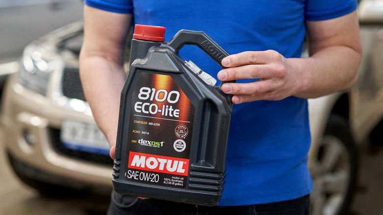 A man holding 0W-20 oil