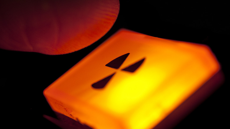 Finger about to press a nuclear launch button.