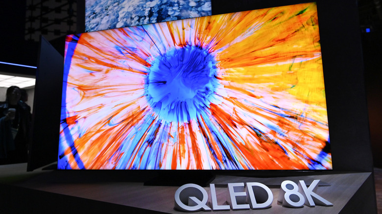 A QLED 8K TV in a store with a brightly-colored display screen