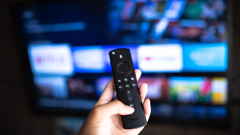 Amazon Fire TV Stick remote with TV in the background