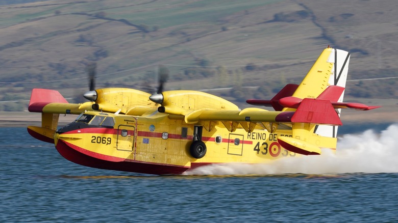 A CL-415 SuperScooper loading up from a body of water.