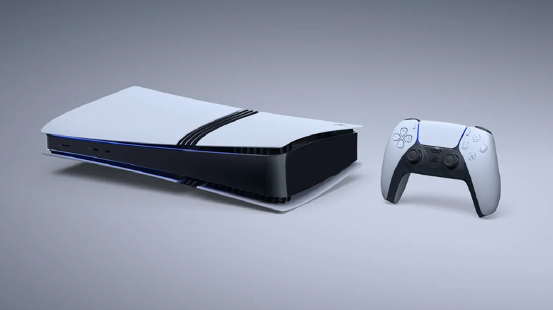 A white PS5 lying on its side with a matching DualSense controller next to it.