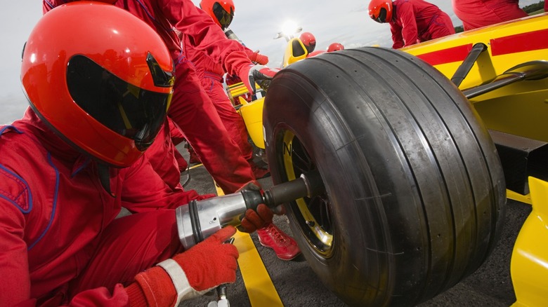 Pit stop crew replacing the tires on an F1 car