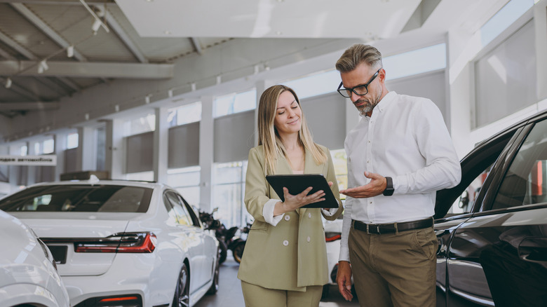 Salesperson with a customer in a car showroom