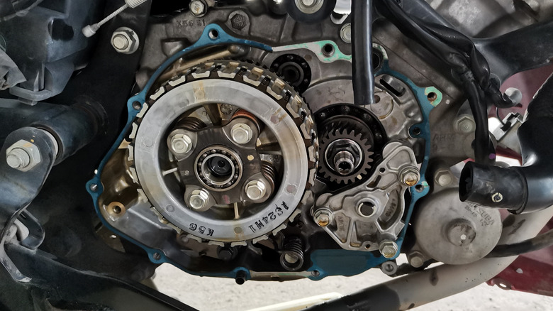 A n image showcasing a motorcycle clutch and other parts of the engine