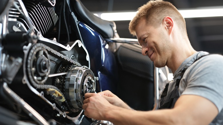 A male mechanic replacing a motorcycle clucth
