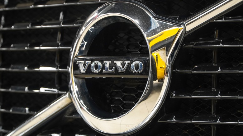 Close up shot of a chrome silver Volvo badge on the front grille.