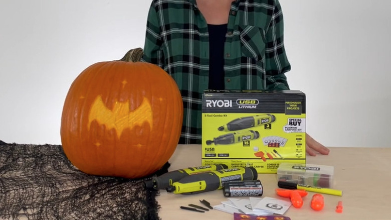 Ryobi pumpkin carving kit next to carved pumpkin